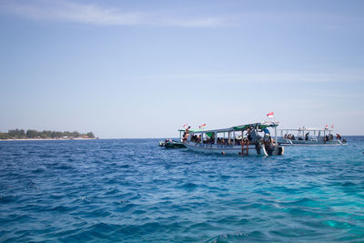 People in sea against clear sky