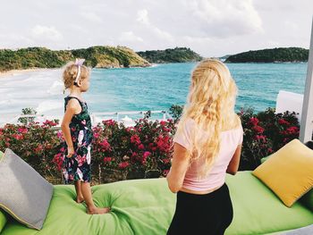 Rear view of woman in sea against sky