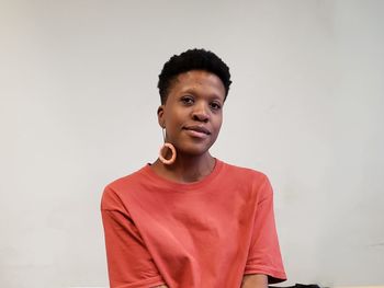 Portrait of young man standing against wall