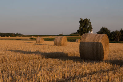 Hay bales on field against sky