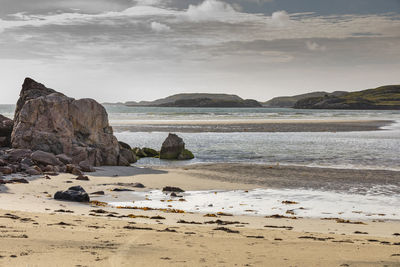 Rocks on beach against sky