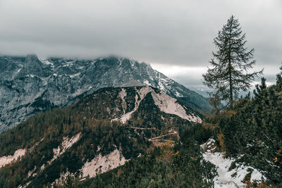 Layer of clouds covering rocky mountain peaks at vrsic mountain pass in julian alps in slovenia