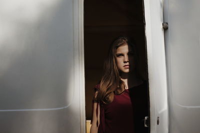 Portrait of young woman standing at entrance