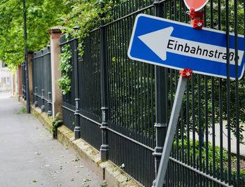 Road sign by fence