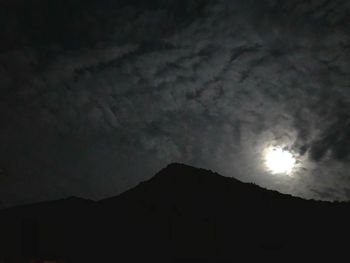 Low angle view of silhouette mountain against sky at night