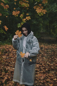 Portrait of young woman standing amidst plants