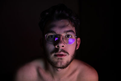 Portrait of young man against black background