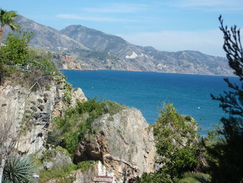 Scenic view of sea and mountains against sky