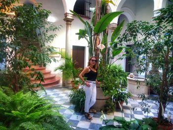 Woman standing by potted plants