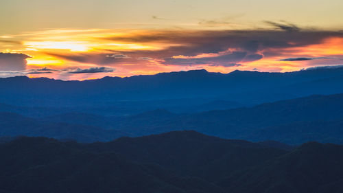 Scenic view of silhouette mountains against sky during sunset