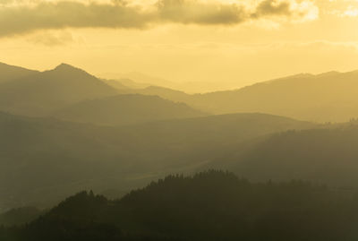 Scenic view of silhouette mountains against sky at sunset