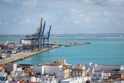 High angle view of cityscape by sea against sky