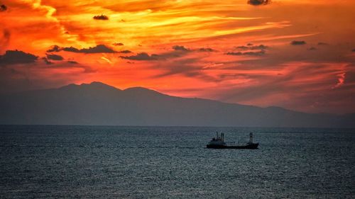 View of boats in calm sea at sunset