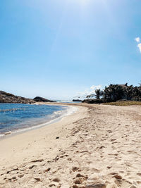 Scenic view of beach against clear blue sky