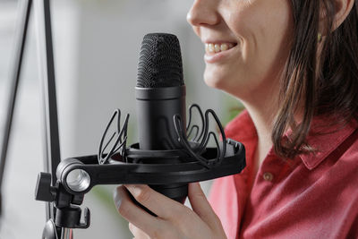 Midsection of woman holding microphone