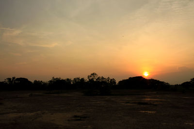 Scenic view of silhouette field against sky during sunset