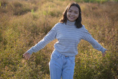 Portrait of smiling young woman standing on land