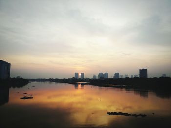 Boats in river with city in background