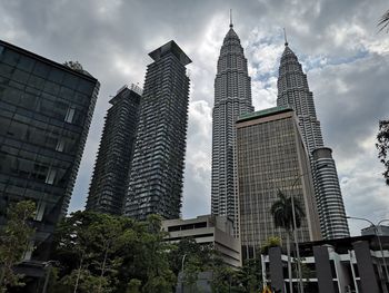 Low angle view of buildings against cloudy sky