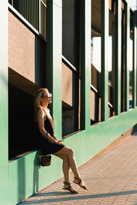 Stylish young woman walking around the city resting sitting on the parking wall