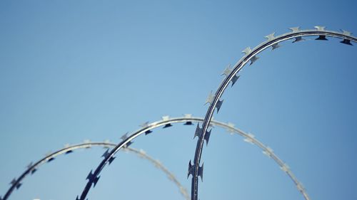 Low angle view of razor wire against clear sky
