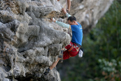 Full length of man climbing rock