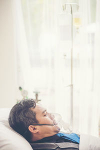 Businessman wearing oxygen mask in hospital