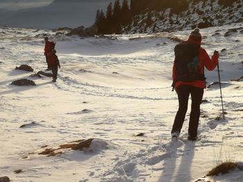 Rear view of man on snow covered field