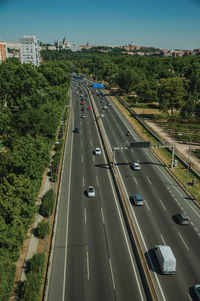 Multi-lane highway with heavy traffic in the midst of trees and buildings in madrid, spain.