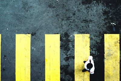 High angle view of yellow arrow symbol on road