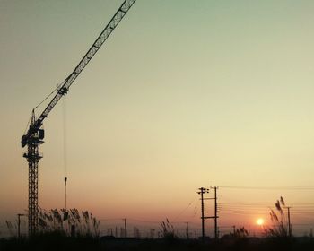 Silhouette of electricity pylon against sky during sunset