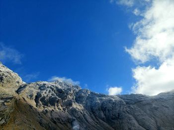 Low angle view of mountain against blue sky
