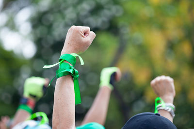 Close-up of man hand with green ribbon