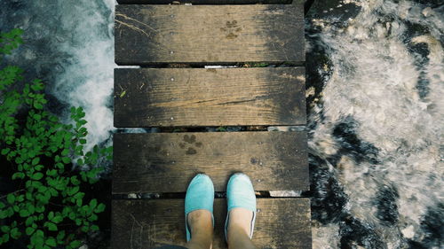 Low section of person standing on narrow bridge