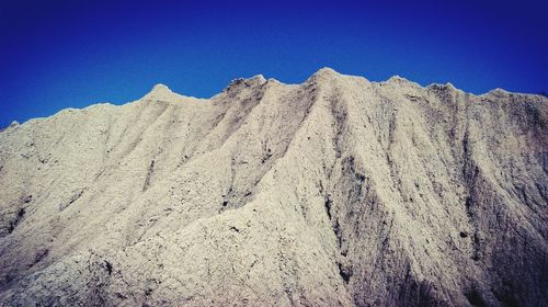 Low angle view of mountain against clear blue sky