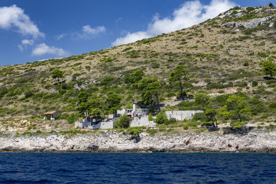 Scenic view of sea by mountains against sky