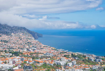 High angle view of townscape by sea against sky