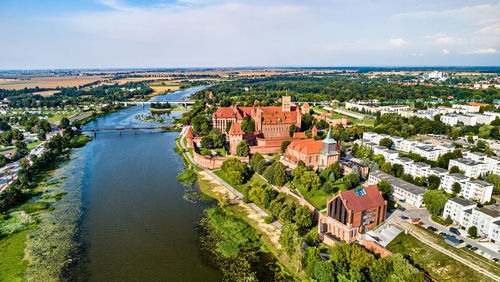 High angle view of river amidst buildings against sky