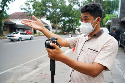 A cameraman wearing a mask directed tallent