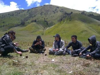 Group of people sitting on grassland