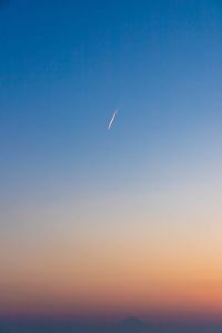 Low angle view of vapor trails in sky during sunset