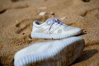 Close-up of shoes on sand