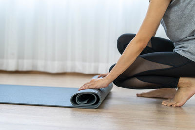 Low section of woman sitting on wooden floor
