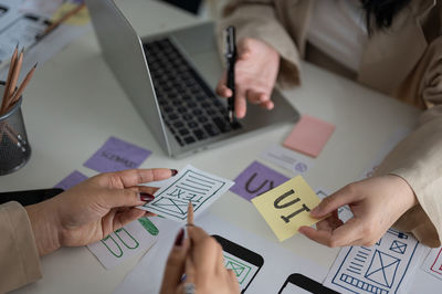 Midsection of business colleagues working on table