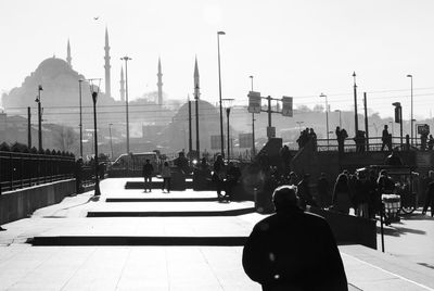 Rear view of people walking on street in city