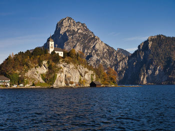 Scenic view of sea by buildings against sky