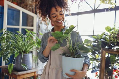 Portrait of woman holding potted plant