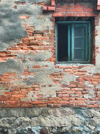 Low angle view of window on brick wall of building