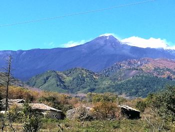 Scenic view of mountains against blue sky