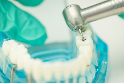 Close-up of artificial teeth with dental equipment on table in medical clinic